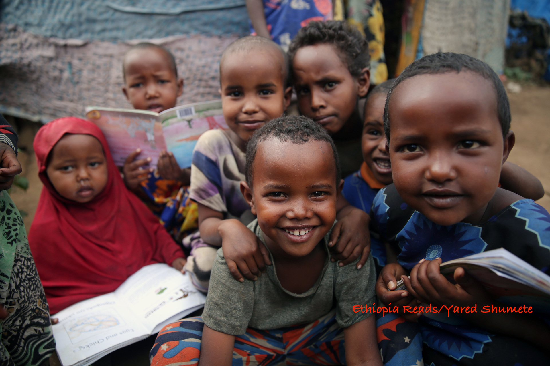 Children receiving books in IDP camp